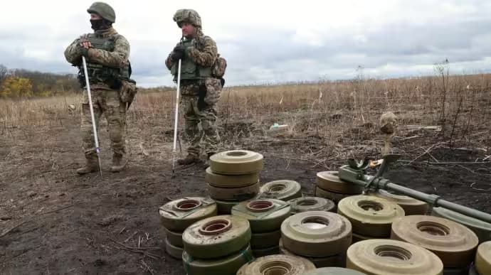 Deminers clearing explosive ordnance in the field